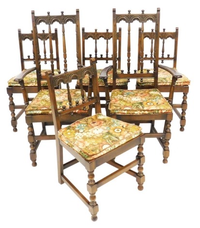 A set of six oak dining chairs in Ercol / Old Charm style, each with a carved back, solid seat with loose cushions, two with arms. The upholstery in this lot does not comply with the 1988 (Fire & Fire Furnishing) Regulations, unless sold to a known export