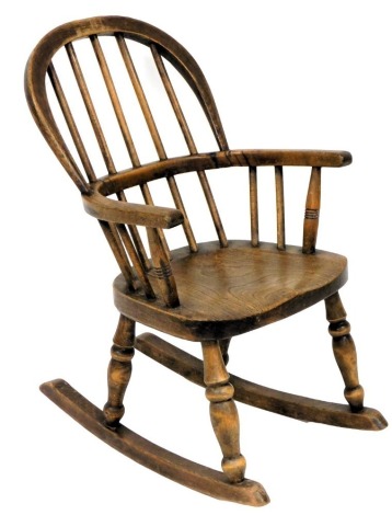 A late 19th/early 20thC ash and elm child's Windsor rocking chair, with spindle turned back, solid seat, on turned legs.