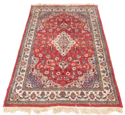 A Persian design rug, with central red ground gul, beige and grey borders, 195cm x 130cm.