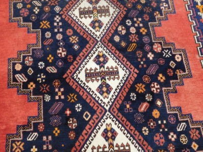 A Turkish design rug, with blue multi gul central field, on a red ground, 237cm x 159cm. - 2