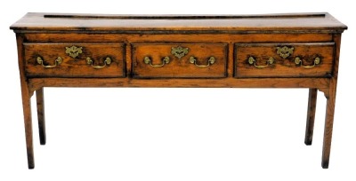 A late 18thC oak dresser, the rectangular top with a raised recess for plates, above three drawers, each with brass drop handles and pierced escutcheons, on square tapering legs, 86cm high, 180cm wide.