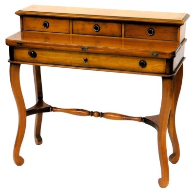 A French fruitwood writing table, the raised back with three frieze drawers, above a hinged writing surface and a drawer, on cabriole legs, with turned stretcher, 85cm high, 91cm wide.