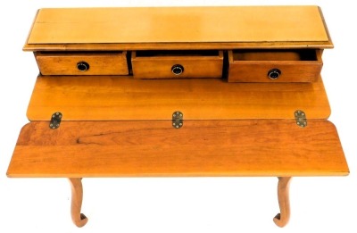 A French fruitwood writing table, the raised back with three frieze drawers, above a hinged writing surface and a drawer, on cabriole legs, with turned stretcher, 85cm high, 91cm wide. - 2