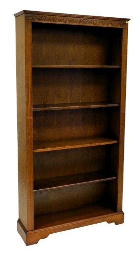 An oak open bookcase, with demi lune frieze, fluted sides and four adjustable shelves, 195cm high, 100cm wide, 26cm deep.