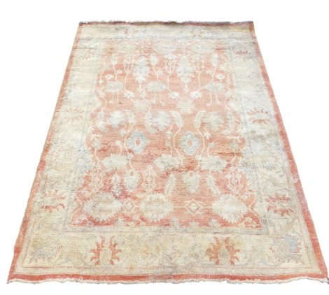 A Ziegler red and cream ground rug, decorated with floral and foliate motifs, within repeating floral borders, 225cm x 178cm.