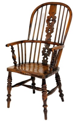 A yew and elm Windsor chair, with a pierced splat, spindle turned rails and a solid seat, on turned legs with H stretcher.