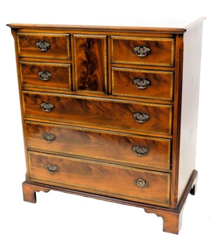 A mahogany and satinwood cross banded television cabinet, formed as a chest of drawers, the rectangular top with a moulded edge, above a top hinged door, formed from a rectangular panel, above four short and two long false drawers, above a real drawer, on