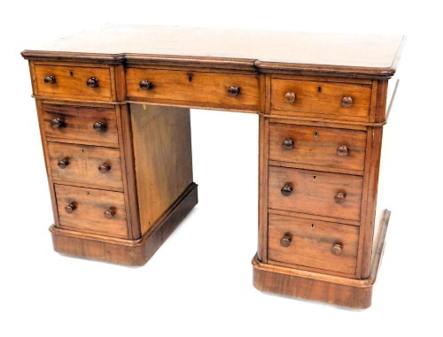 A 19thC mahogany kneehole desk, the rectangular inverted breakfront top with a moulded edge, above an arrangement of nine drawers, each with turned handles, on a plinth base, 80cm high, 121cm wide, 59cm deep. (AF)