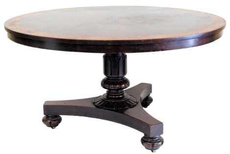 A William IV figured mahogany and burr yew breakfast table, the circular top with radiating veneers, on a leaf carved turned column and triform base, with bun feet, 137cm diameter.