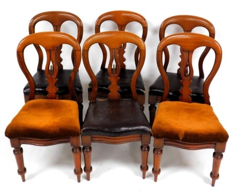 A set of six Victorian mahogany balloon back dining chairs, with a carved splat, and overstuffed brown leatherette seats, raised on turned legs.