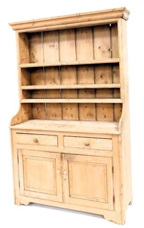 A Victorian stripped pine dresser, with moulded cornice, plate rack top, two drawer and two door cupboard base, 210cm high, 130cm wide, 50cm deep.