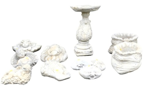 A group of concrete garden ornaments, including cherubs and a lion's head, together with a pair of planters modelled as tied bags, and a birdbath. (11)