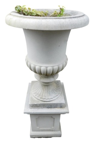 A stone campana urn with part reeded body, and square base, 124cm high.