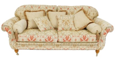 A large deep seated sofa, upholstered in gold, red and silvered pattern fabric, on turned and reeded legs with brass castors, 201cm wide, and a matching smaller sofa, 176cm wide. (2) - 3