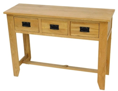 A light oak side table, with three frieze drawers, on stiles, 78cm high, 110cm wide.