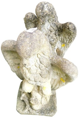 A pair of reconstituted stone gate finials, each modelled in the form of a heraldic eagle, on a square base, 47cm high.