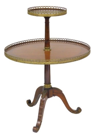 A late 19th/early 20thC Continental mahogany and gilt brass two tier dumbwaiter, with a pierced gallery, turned column and tripod base, possibly French, 93cm high, 72cm diameter.