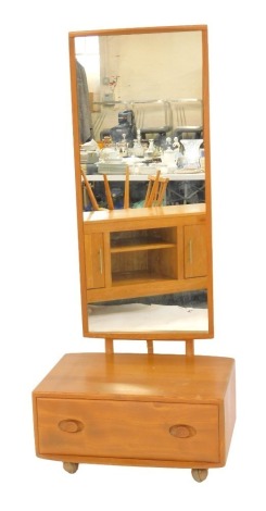 An Ercol cheval mirror, the mirror plate of rectangular form, above a base with drawer, on castors, 166cm high, 66cm wide, 45cm deep.