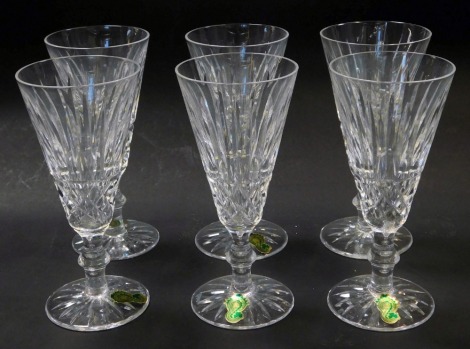 A set of six Waterford crystal Tramore pattern fluted champagne glasses, some with paper labels, 16cm high.