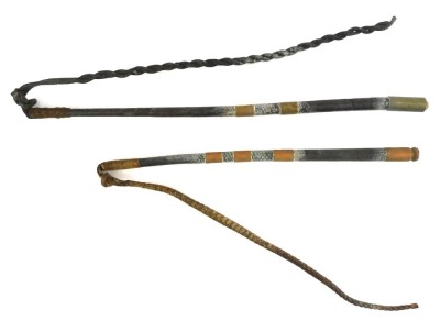 Two similar leather riding whips, each with a leather handle, with copper banding and braided leather ends, each approx 110cm long.