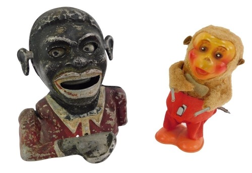 A 20thC Hong Kong clockwork windup toy, modelled as a monkey, impressed mark to underside, Made in Hong Kong, 14cm high (AF), together with a cast metal money box, modelled as a gentleman wearing a red jacket, 17cm high.These items are listed on the basis