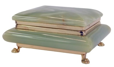 A 1920s green onyx cigarette box, the rectangular hinged top opening to reveal a vacant interior above a large rectangular base raised on four cast brass paw feet, 12.5cm wide.