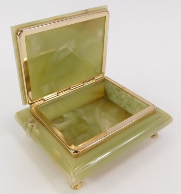 A 1920s green onyx cigarette box, the rectangular hinged top opening to reveal a vacant interior above a large rectangular base raised on four cast brass paw feet, 12.5cm wide. - 2