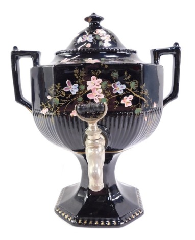 A Victorian pottery two handled samovar, decorated with hand painted flowering branches against a black glazed ground with gilt highlights, 36cm high.