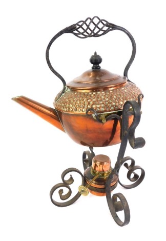 A late 19th/early 20thC Arts & Crafts copper teapot on stand, the teapot with hammered decoration, cast iron handle, on a cast iron stand with copper and brass burner, 35cm high.