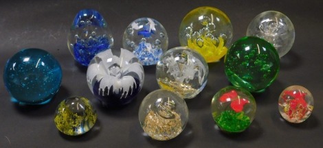 A group of paperweights, comprising a green and red butterfly domed paperweight, a turquoise bubbled paperweight, stardust, blue and white swallow weight, yellow bubble weight, etc. (12)