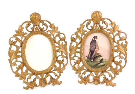 A pair of late 19th/early 20thC gilt metal photograph frames, each with an oval crest, with arched and shell capped top, one inset with a print of a falcon, 29cm x 22cm.