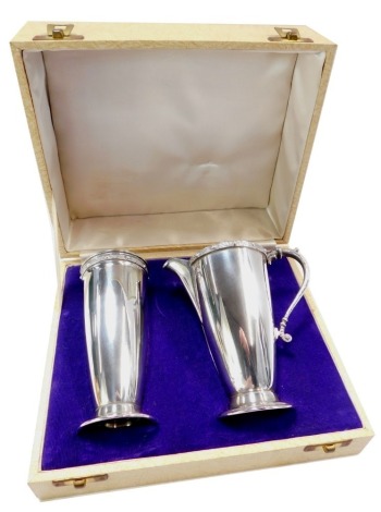 An Elizabeth II silver milk jug and sugar caster set, with a serpent moulded handle and Celtic hammered border, maker D L, Birmingham 1967, in fitted case, 9.27oz.