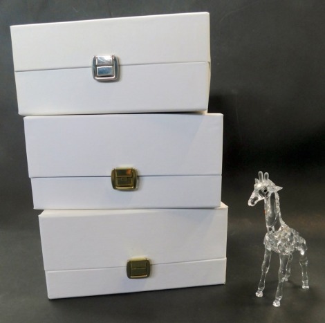 A Swarovski crystal figure modelled as a giraffe, 14cm high, boxed, together with two further boxes, lacking contents.