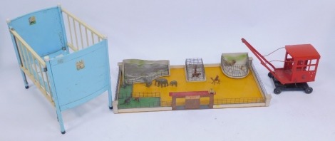 A Chiltern Toys metal and wooden framed toy cot, together with a mid century zoo play set, with various animal figures, tinplate crane, etc.