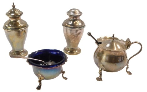 An Edward VII and later four piece matched silver cruet set, comprising salt and pepper pot, mustard, on tripod feet with fluted border and blue glass liner, and a salt, with one silver and one silver plated spoon, 5.21oz. (6)