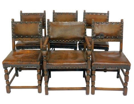 A set of six oak dining chairs, each with a leather seat and back with stud work, on turned legs united by stretchers (4+2).