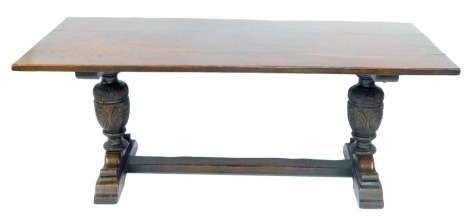 An oak refectory table in 17thC style, the planked top, on leaf carved cup and cover supports and splayed feet with flat stretcher, 76cm high, 192cm wide, 85cm deep.