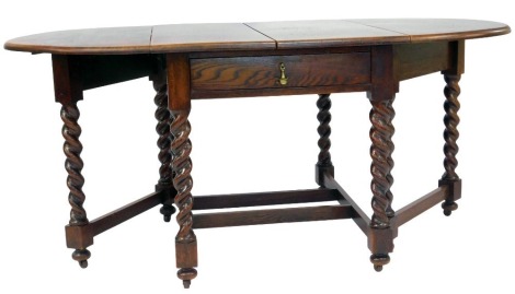 An early 20thC oak gate leg table, the top with a rounded edge, raised on spiral turned legs united by stretchers, on castors, 77cm high, the top 79cm x 102cm, approx 179cm extended.