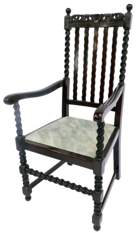 An early 20thC oak carver chair in Carolean style, with scroll and floral carved rail, waved splats with spiral turned columns, solid arms and spiral turned columns, drop-in seat, turned legs united by stretchers.