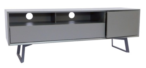 A modern TV unit, in grey, the rectangular top with a recess and drawer beside a cupboard, on black metal legs, 55cm high, 159cm wide, 45cm deep.