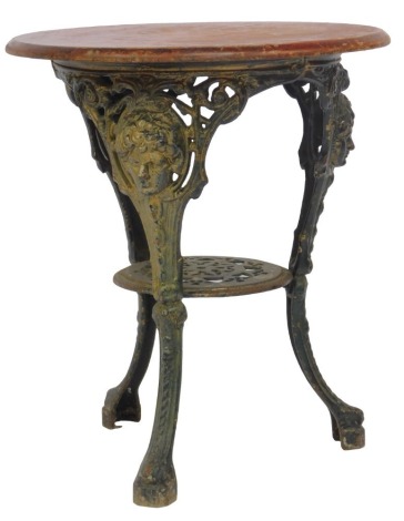 An early 20thC pub table, the stained oak top above a cast iron base decorated with masks, scrolls, etc., with a pierced under tier, on cabriole legs, 70cm high, the top 58cm diameter.