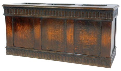 An oak coffer, the three-panelled hinged top enclosing a vacant interior, the front with three panels, with a carved top and base border, 51cm high, 105cm wide, 40cm deep.