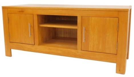 A contemporary oak television cabinet, the rectangular top above two recesses flanked by two cupboards, on stiles, 60cm high, 138cm wide, 50cm deep.