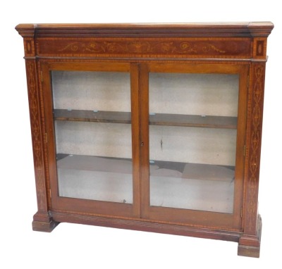 A late 19th/early 20thC mahogany satinwood and marquetry bookcase, the inverted break front top with a moulded edge, above an inlaid frieze, two glazed doors, on block feet, 114cm high, 126cm wide.