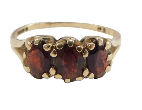 A 9ct gold garnet cluster ring, set with three oval garnets, each in claw setting, on V splayed shoulders, ring size L½, 1.8g all in.