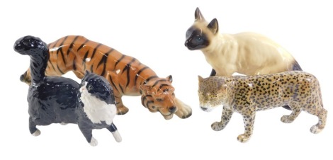 Four ceramic animal ornaments, comprising a Coopercraft Siamese cat, a tiger stamped Foreign, a USSR leopard, and a Royal Doulton cat, the largest 14cm high. (4)