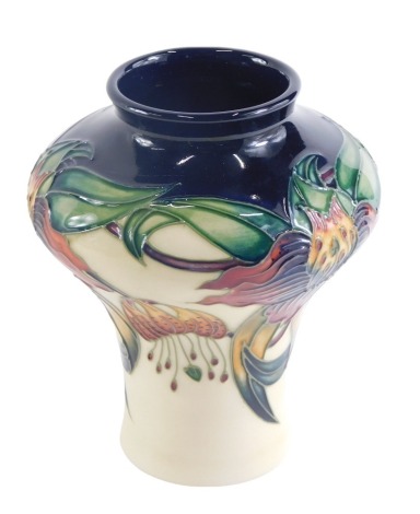 A Moorcroft Anna Lily pattern vase, on a blue ground, with a cream border, dated 98 in red, 13cm high, boxed.