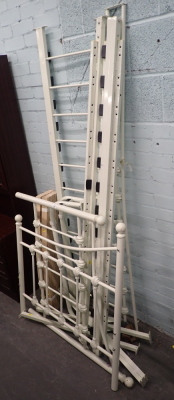 A cream painted metal single bed frame.