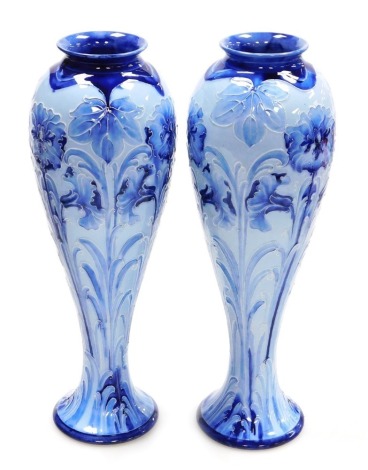 A pair of early 20thC Moorcroft Florian ware pottery vases, of slender baluster form, decorated in the Dianthus pattern, printed and painted marks, 30cm high.