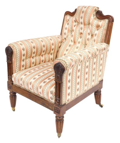 A George IV mahogany library chair, having a carved crest rail and arm terminals, with fluted and leaf carving, upholstered in button back striped pink and floral fabric, raised on fluted legs, brass capped on castors, 72cm wide, 82cm deep.